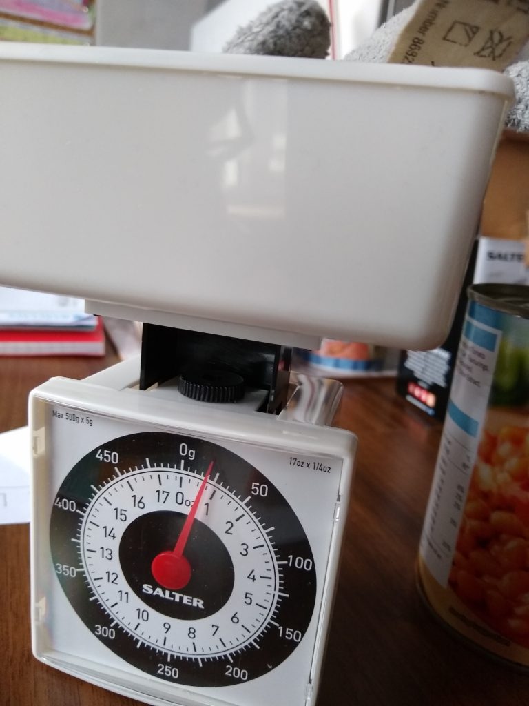 A toy shark on the weighing scales that are showing 20 g.