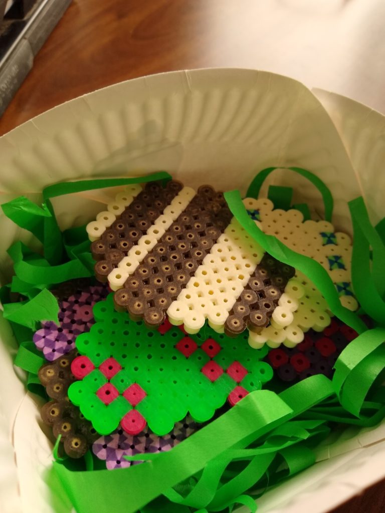 A photo showing the Easter eggs in the paper plate Easter basket with some green tissue paper strips.