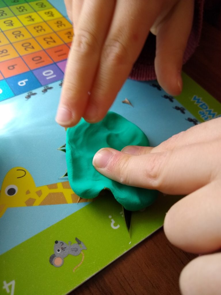 A photo showing me pressing the clay onto the leaf.