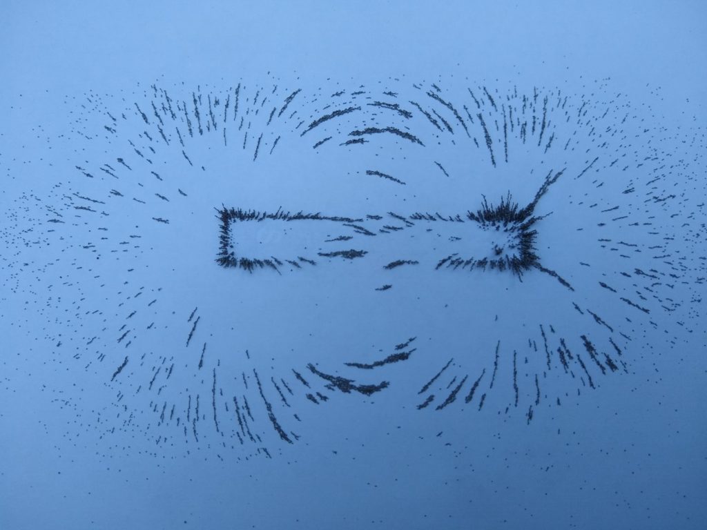 A photo of iron filings showing the magnetic field round a magnet.