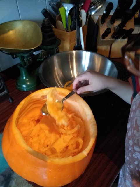 A photo of me scooping out some orange flesh.
