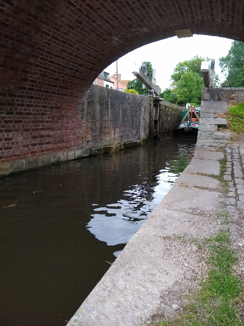 A photo of a canal boat coming out of a lock.