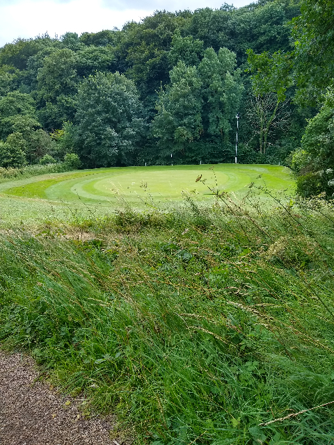 A photo looking downhill to a golfing green.