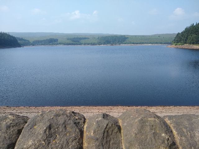 A view peering over the dam wall to the reservoir.