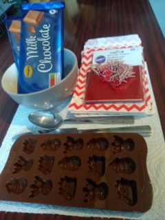 A photo of the equipment: a mould, a knife, a spoon, chocolate