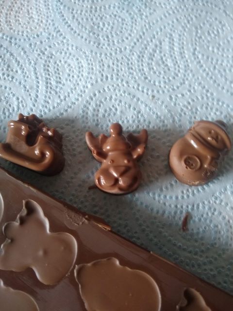 A photo of the first of each shaped chocolate: a reindeer face, a snowman and a sleigh.