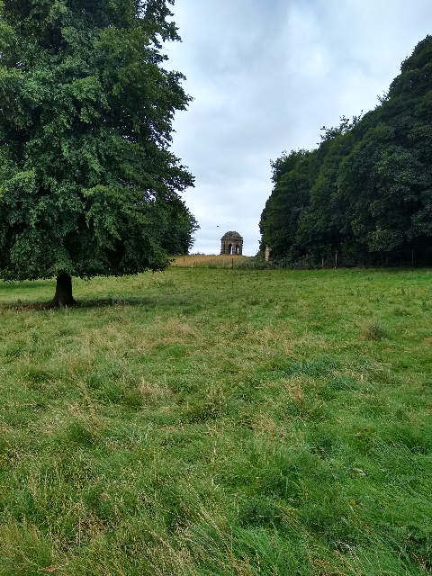 A photo of a small stone structure, comprising pillars and a domed roof.