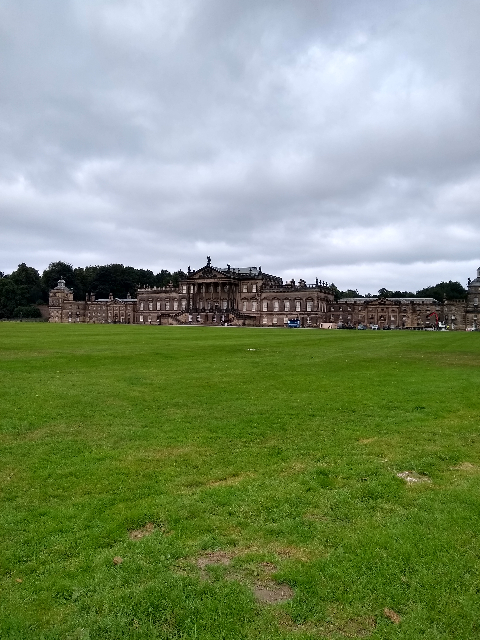 A photo of a huge mansion with lawns to the front.